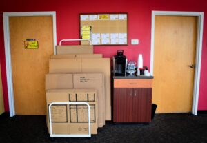 stacked moving boxes, name-contents labels, and coffee station in the office at AA Self Storage in Jacksonville NC