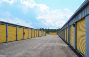 long exterior row of yellow roll-up doors on storage units at AA Self Storage in Jacksonville NC under blue sky