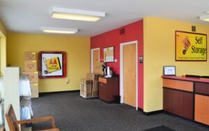 customer waiting area and packing supplies display inside AA Self Storage office in Jacksonville NC with yellow and red walls