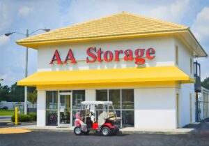 AA Self Storage office building with bright yellow roof and awning and red golf cart parked in front in Jacksonville NC